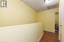 Hallway with attic access, dark wood-type flooring, and a textured ceiling - 