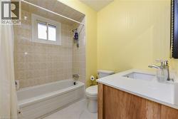 Full bathroom with vanity, shower / tub combo with curtain, and light tile patterned flooring - 