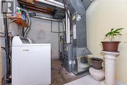 Utility room featuring washer / dryer, heating unit, and gas water heater - 