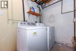 Washroom featuring washer and clothes dryer and unfinished concrete floors - 