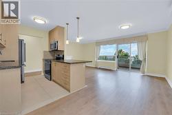 Kitchen featuring light brown cabinets, dark stone counters, and appliances with stainless steel finishes - 