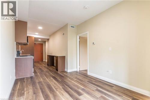 Unfurnished living room with dark wood-style floors and recessed lighting - 580 Coldstream Drive Unit# 212, Waterloo, ON - Indoor Photo Showing Other Room