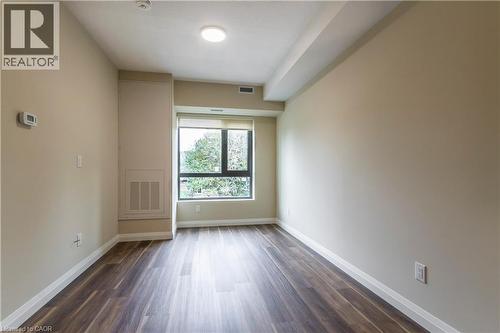 Spare room featuring baseboards and dark wood-type flooring - 580 Coldstream Drive Unit# 212, Waterloo, ON - Indoor Photo Showing Other Room