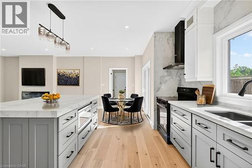 Kitchen featuring gray cabinetry, light stone counters, hanging light fixtures, electric range, and white cabinetry - 4006 Flemish Drive, Burlington, ON - Indoor Photo Showing Kitchen