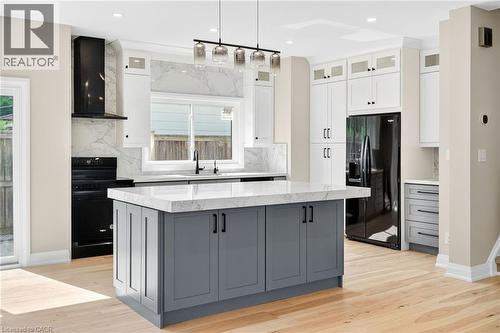 Kitchen featuring gray cabinetry, black appliances, white cabinets, wall chimney exhaust hood, and a kitchen island - 4006 Flemish Drive, Burlington, ON - Indoor Photo Showing Kitchen With Upgraded Kitchen