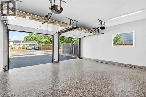 Garage featuring a garage door opener and baseboards - 4006 Flemish Drive, Burlington, ON - Indoor Photo Showing Garage