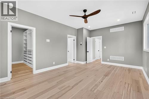 Unfurnished bedroom with a walk in closet, light wood-style flooring, a ceiling fan, and recessed lighting - 4006 Flemish Drive, Burlington, ON - Indoor Photo Showing Other Room