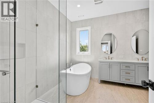 Bathroom with tile walls, a freestanding tub, double vanity, a stall shower, and recessed lighting - 4006 Flemish Drive, Burlington, ON - Indoor Photo Showing Bathroom