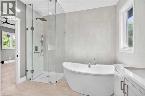 Full bathroom with a stall shower, a freestanding tub, vanity, and tile walls - 4006 Flemish Drive, Burlington, ON - Indoor Photo Showing Bathroom