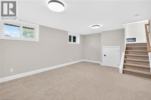 Below grade area with light colored carpet and stairway - 4006 Flemish Drive, Burlington, ON - Indoor Photo Showing Other Room