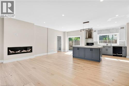 Kitchen featuring gray cabinetry, decorative light fixtures, a glass covered fireplace, plenty of natural light, and recessed lighting - 4006 Flemish Drive, Burlington, ON - Indoor