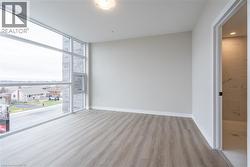 Empty room featuring expansive windows and light hardwood / wood-style floors - 