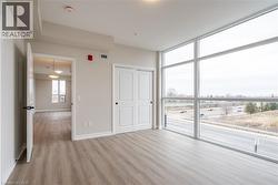 Unfurnished bedroom featuring a wall of windows, a closet, and light wood-type flooring - 