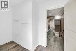 Hallway with light wood-style flooring and recessed lighting - 