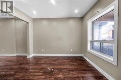 Empty room with dark wood-type flooring and baseboards - 