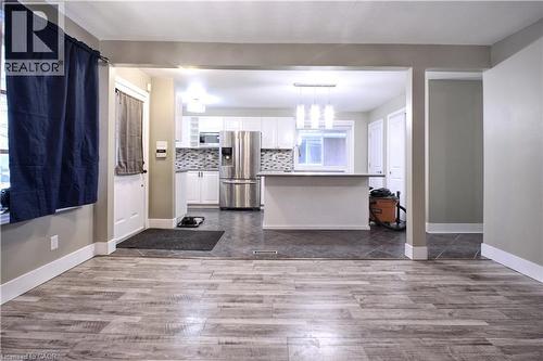 Kitchen with white cabinetry, stainless steel appliances, light countertops, pendant lighting, and dark wood-style flooring - 61 Bosworth Crescent, Kitchener, ON - Indoor