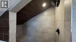 Bathroom view of tiled shower and recessed lighting - 