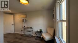 Living area featuring dark wood-style flooring and baseboards - 