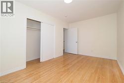 Unfurnished bedroom featuring light wood finished floors and a closet - 