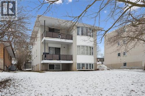 Snow covered rear of property with a balcony and brick siding - 24 Austin Drive, Waterloo, ON - Outdoor