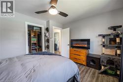 Bedroom with ceiling fan, wood finished floors, and a closet - 