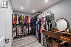 Walk in closet with light wood-style flooring - 