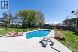 View of pool with a patio and a fenced backyard - 