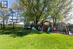 Fenced backyard with a trampoline and a playground - 