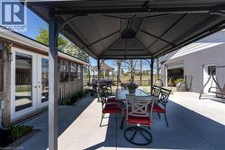 View of patio / terrace with french doors, outdoor dining space, a gazebo, and a grill - 