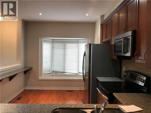 Kitchen featuring appliances with stainless steel finishes, light wood-style floors, recessed lighting, and tasteful backsplash - 4294 Ingram Common, Burlington, ON - Indoor Photo Showing Kitchen