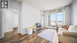 Living area with dark wood-style flooring and a wall of windows - 