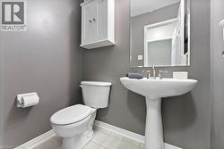 Half bath featuring light tile patterned floors and baseboards - 
