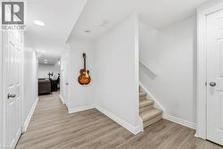 Hall with light wood-type flooring, stairway, and recessed lighting - 