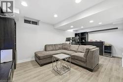 Living room featuring beverage cooler, light wood-style flooring, and recessed lighting - 