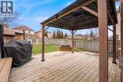 Deck featuring grilling area, a fenced backyard, a gazebo, and a residential view - 
