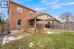 Rear view of house featuring brick siding, a gazebo, and a wooden deck - 