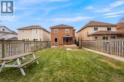 Rear view of property with a gazebo, a deck, a fenced backyard, and a residential view - 