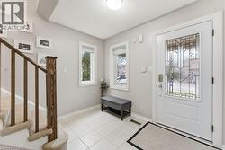 Foyer with stairs, light tile patterned floors, and a textured ceiling - 