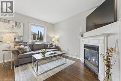 Living area with a glass covered fireplace and dark wood-style floors - 