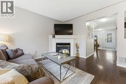 Living area with a glass covered fireplace and dark wood-style flooring - 