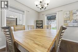 Dining room featuring dark wood-style flooring, a chandelier, and ornamental molding - 