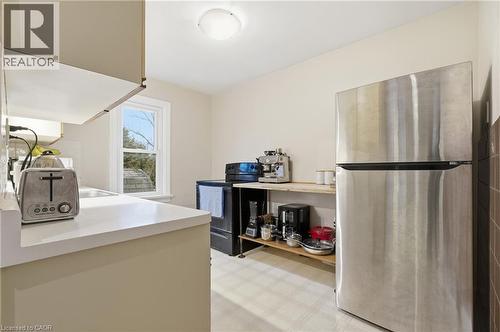 Kitchen with light flooring, freestanding refrigerator, black / electric stove, and light countertops - 157 Bridgeport Road E, Waterloo, ON - Indoor