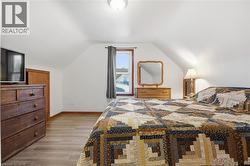 Bedroom featuring light wood finished floors and vaulted ceiling - 