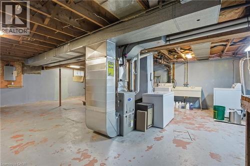 Unfinished below grade area featuring washing machine and dryer, heating unit, and electric panel - 157 Bridgeport Road E, Waterloo, ON - Indoor Photo Showing Basement