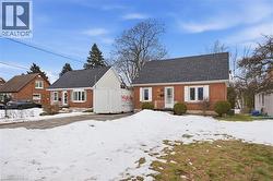 View of front of property featuring brick siding and roof with shingles - 
