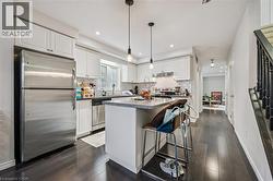 Kitchen with a breakfast bar area, appliances with stainless steel finishes, white cabinets, a center island, and decorative backsplash - 