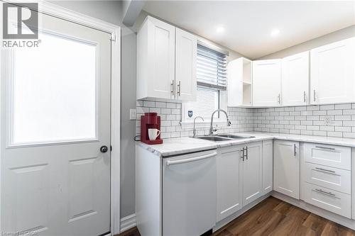 Kitchen featuring white dishwasher, light countertops, white cabinets, decorative backsplash, and recessed lighting - 140 Royal Avenue, Hamilton, ON - Indoor Photo Showing Kitchen With Double Sink