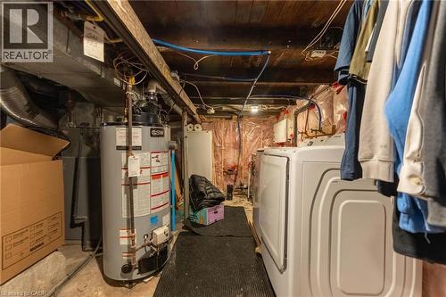 Unfinished basement featuring gas water heater and separate washer and dryer - 140 Royal Avenue, Hamilton, ON - Indoor Photo Showing Basement
