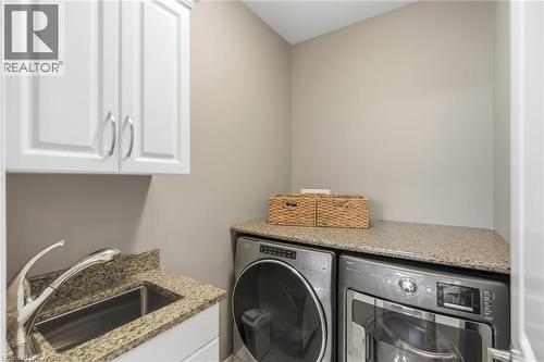 Convenient main floor laundry/ stone countertop - 21 Tulip Tree Road, Niagara-On-The-Lake, ON - Indoor Photo Showing Laundry Room