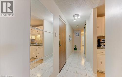 Hall featuring a textured ceiling and light tile patterned floors - 4 Avalon Place Unit# 103, Kitchener, ON - Indoor Photo Showing Other Room